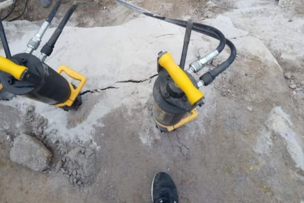 A hydraulic rock splitter demonstrating the rock splitting method on a large boulder.